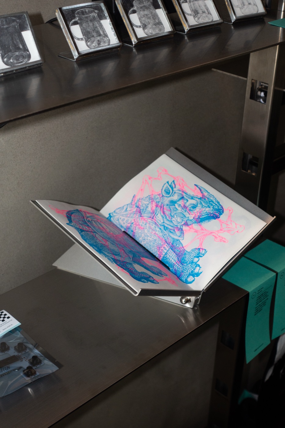 A BS-2 holding an open riso-printed book in a shop