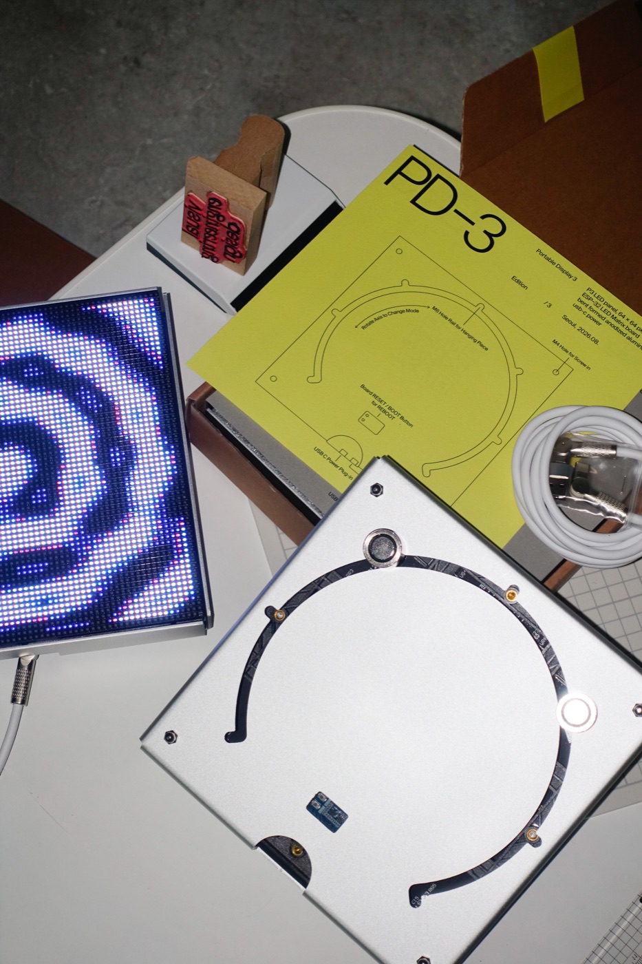 A running PD-3 unit beside its printed sheet and bare backplate