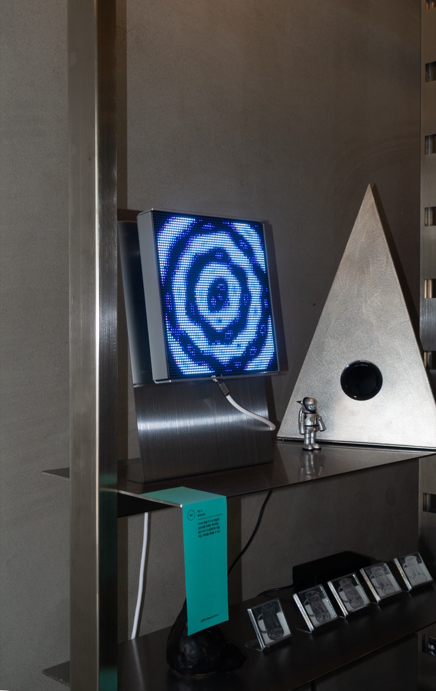 A PD-3 running on a shop shelf beside a metal triangle